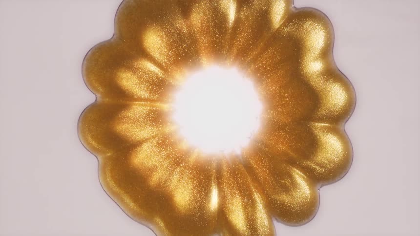 A mesmerizing top-down view of a golden glittery liquid swirling in a flower shape around a bright central light