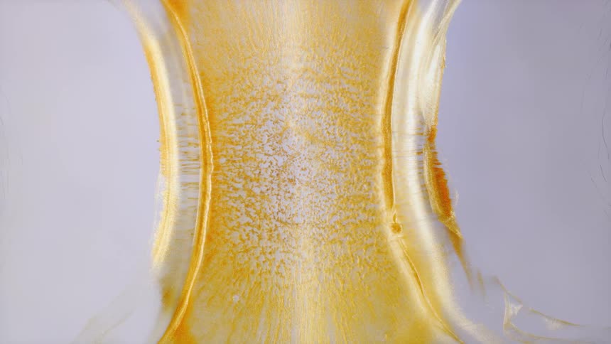 Golden metallic liquid slowly contracts in an hourglass shape against a white background in this abstract macro shot