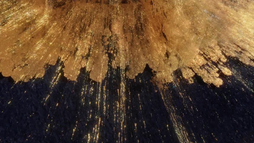 Shimmering gold liquid with sparkling glitter particles flows down a dark textured surface