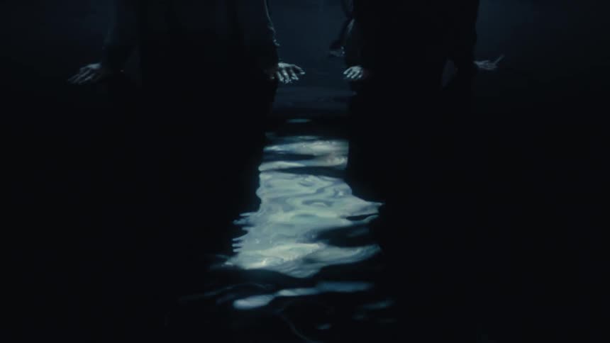 A cinematic shot of two dark silhouetted figures on either side of a moonlit, rippling water reflection