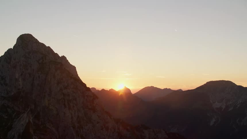 The sun sets over mountain peaks