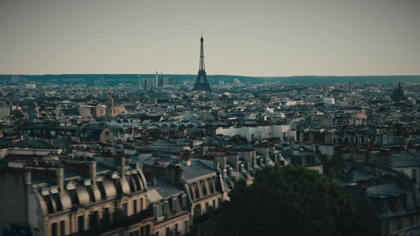A cinematic shot pans from behind trees to reveal the iconic Paris cityscape, with the Eiffel Tower in the distance