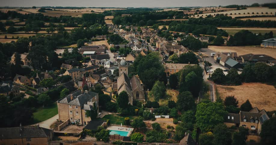 Drone footage reveals the idyllic charm of a historic English village, slowly flying over the traditional stone houses and church