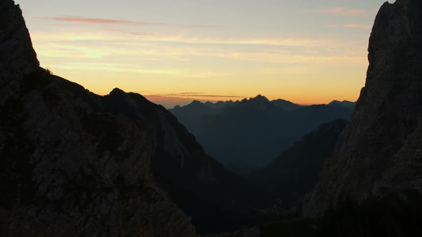 Sun sets over jagged peaks of a mountain range