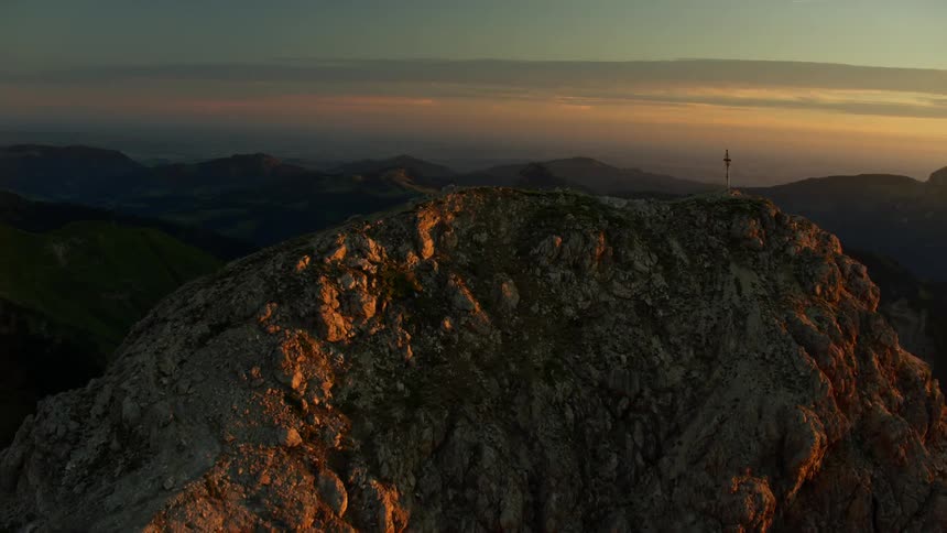 Cross on top of a mountain at sunrise