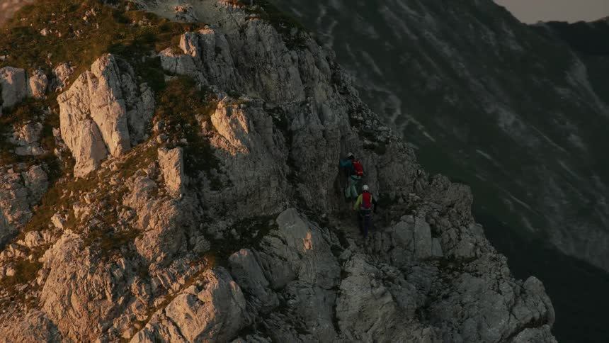 Two rock climbers are ascending a steep mountain peak
