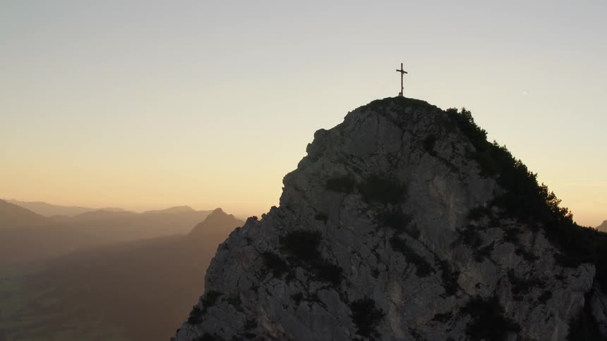 Moving up the tall mountain a cross is at the top