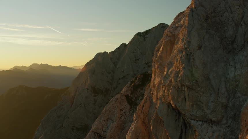The mountain is clear and has the sun setting behind