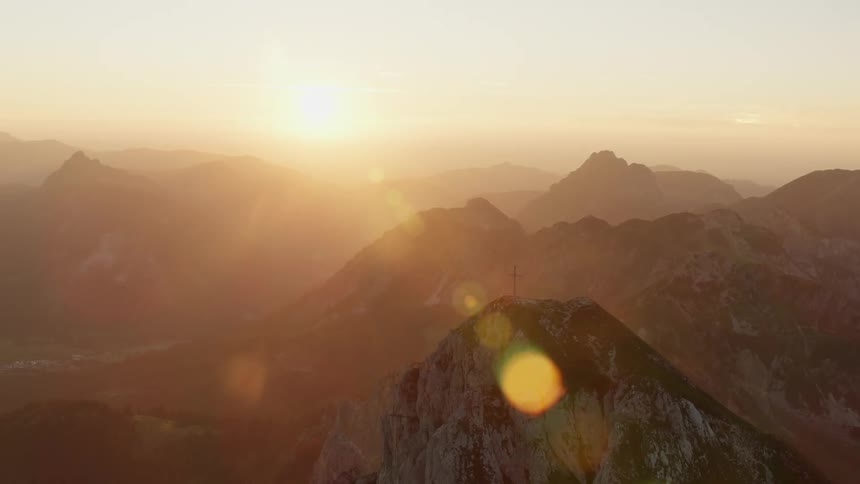 Cross on top of a mountain at sunrise