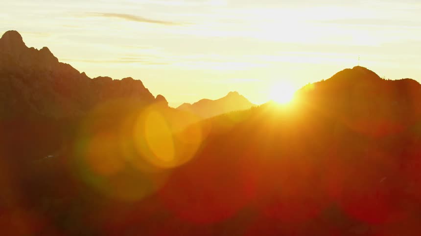 The setting sun peeks through the mountains