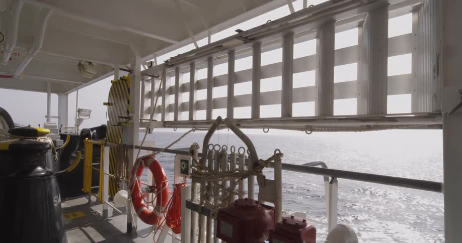A view of the sparkling sunlit ocean from the deck of a moving ship