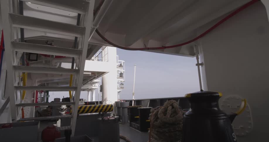 A view of the calm open ocean from the shaded deck of a large industrial ship