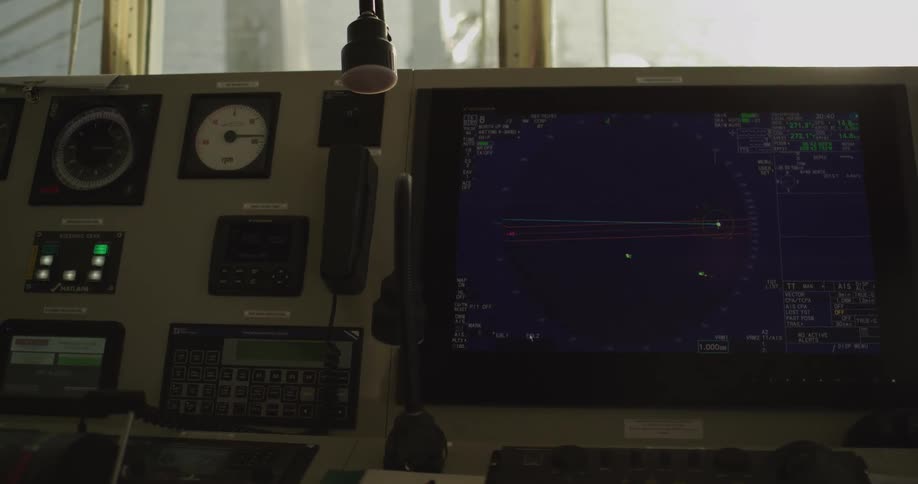 A modern ship's bridge with a navigation radar screen and various control panels