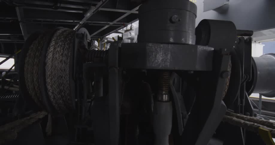 Interior view of the dark and mechanical mooring deck of a large industrial ship