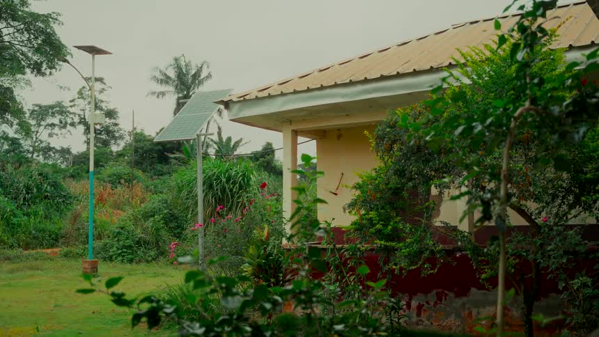 A modern solar panel provides sustainable energy to a building nestled in a lush, green, rural landscape