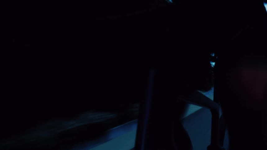 Close-up of a cyclist's legs and bicycle frame during an intense night ride on a dark road