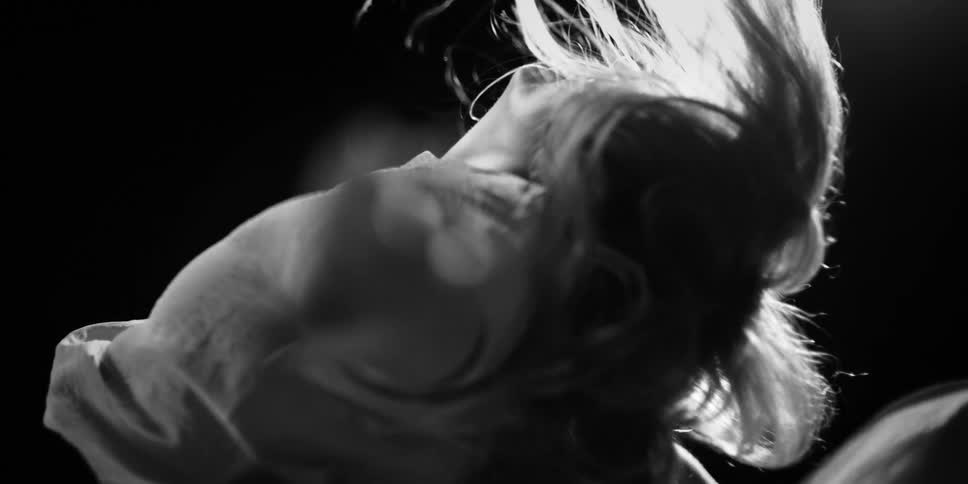 Dramatic black and white close-up of a person's hair flowing in super slow motion