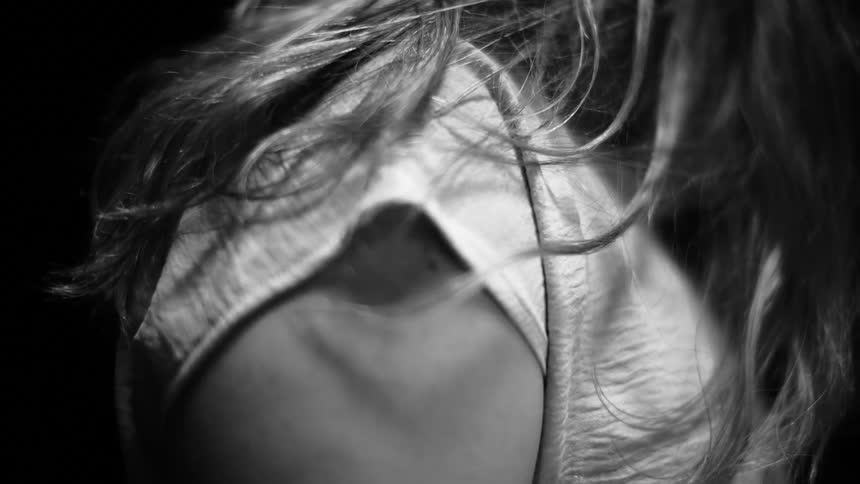 A slow focus pull reveals a woman's lower back and butt in an intimate black and white close-up shot