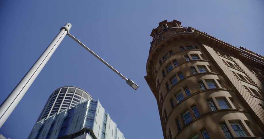 Contrasting modern and classic architectural styles of city skyscrapers tower against a clear blue sky