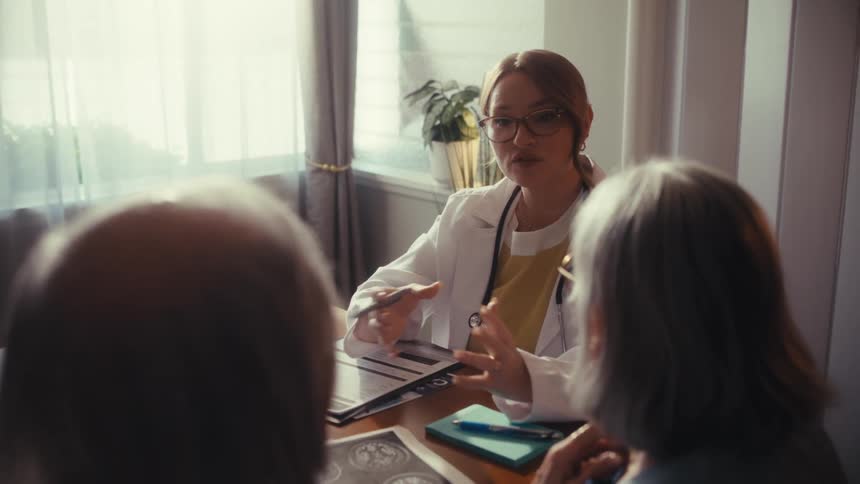 An empathetic doctor consults with a senior couple, reviewing brain scan images and providing medical advice in an office