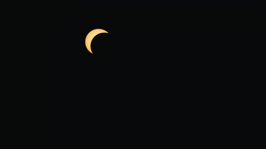A stunning time-lapse captures a partial solar eclipse moving across the dark night sky