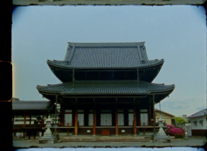 A slow zoom out reveals a traditional Japanese temple on an overcast day, captured on vintage 8mm film