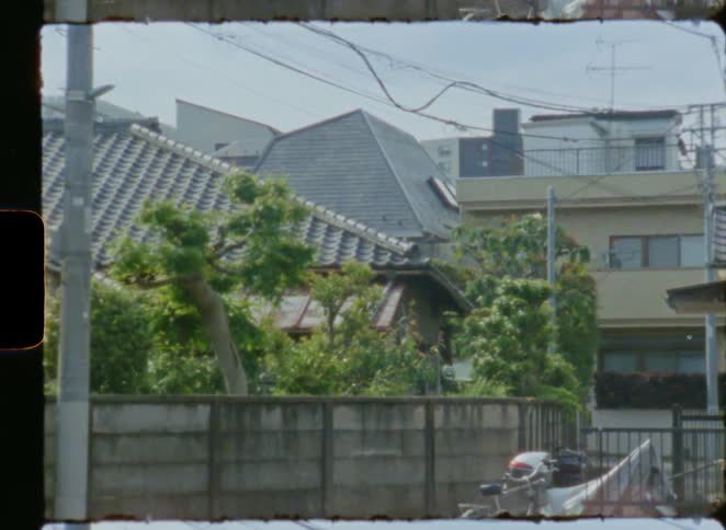 Vintage super 8mm film footage of a traditional Japanese house in a quiet suburban neighborhood
