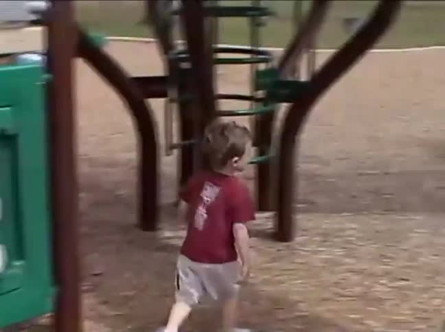 Vintage home movie footage of a little boy playing with a tic-tac-toe game at a park playground