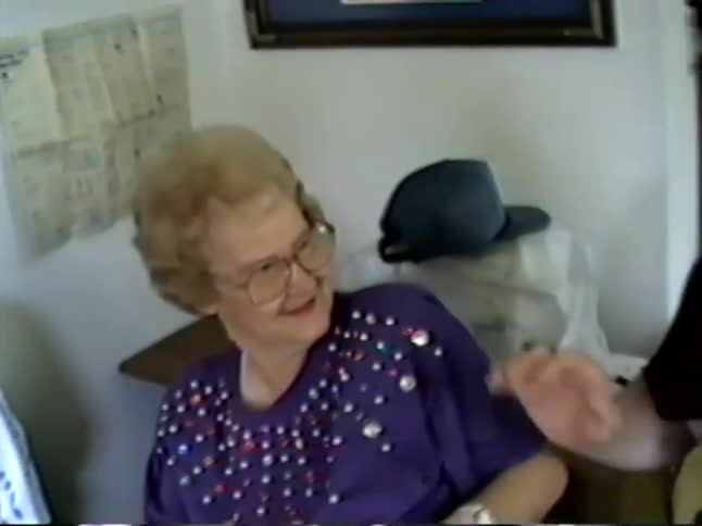 Vintage VHS footage captures a heartwarming family gathering where a woman waves excitedly and makes a funny face for the camera