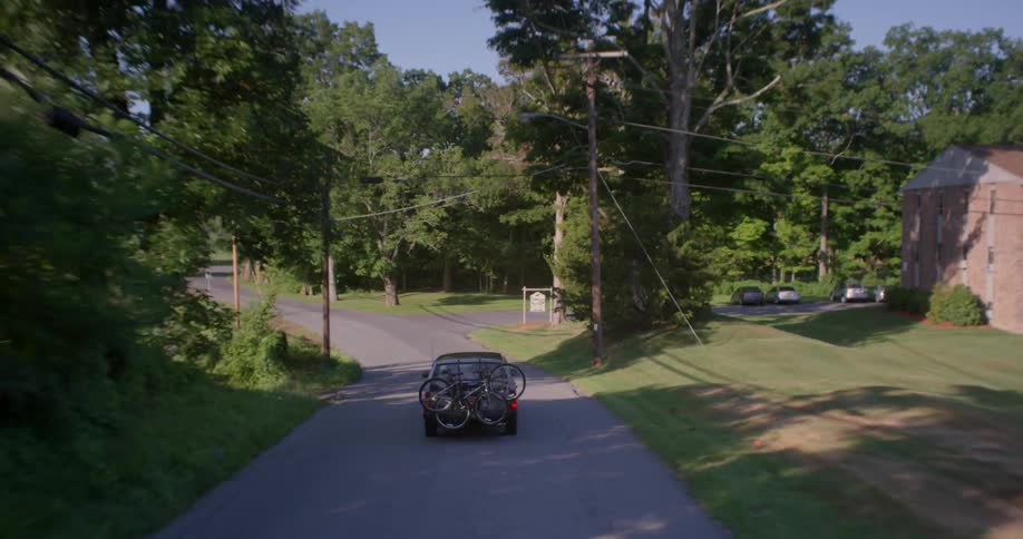 The car drives carrying bicycles on it's back