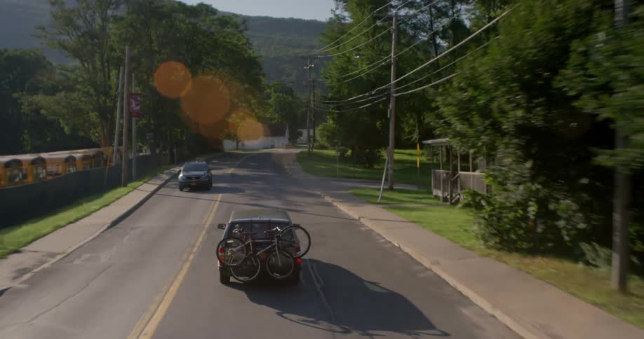 Cars travel down the road on a sunny day