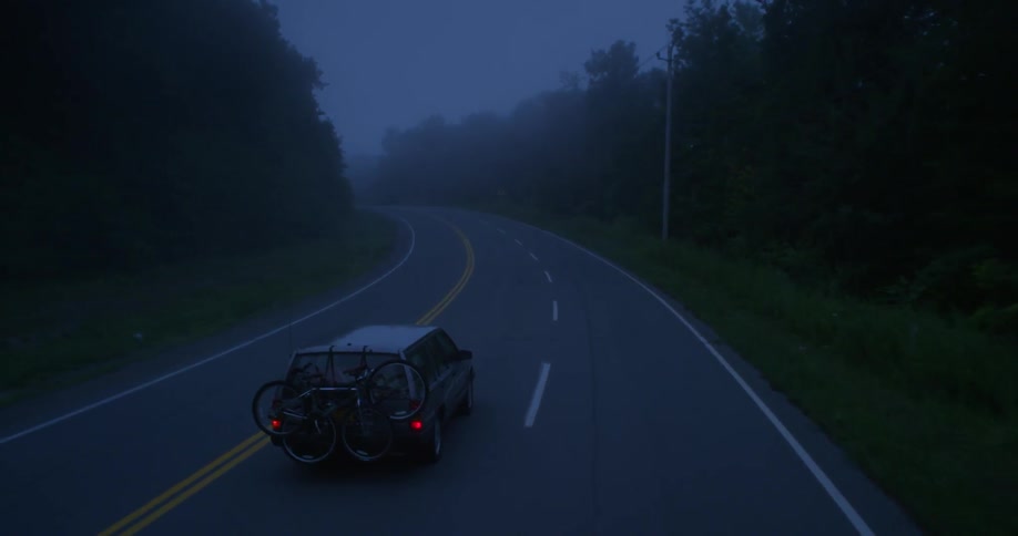 Car driving down a country road at night