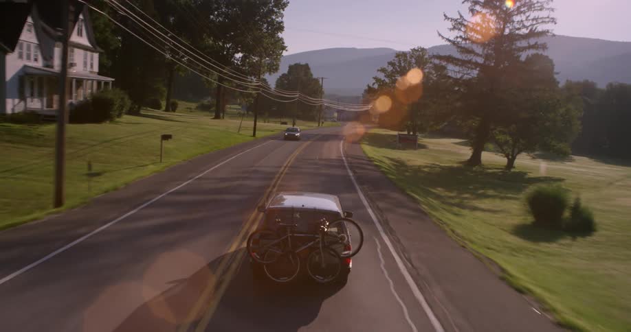 Vehicle driving down a rural road carrying bicycles on its rear