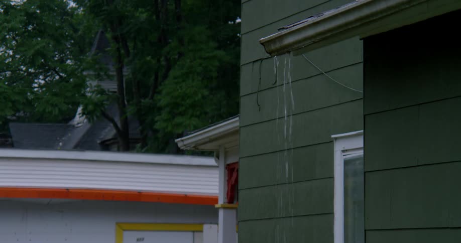 Water pours off of a roof