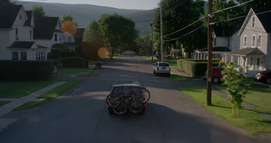 Car drives in a neighborhood in a small town