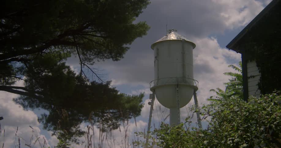 Clouds hover over a water tower in a rural area