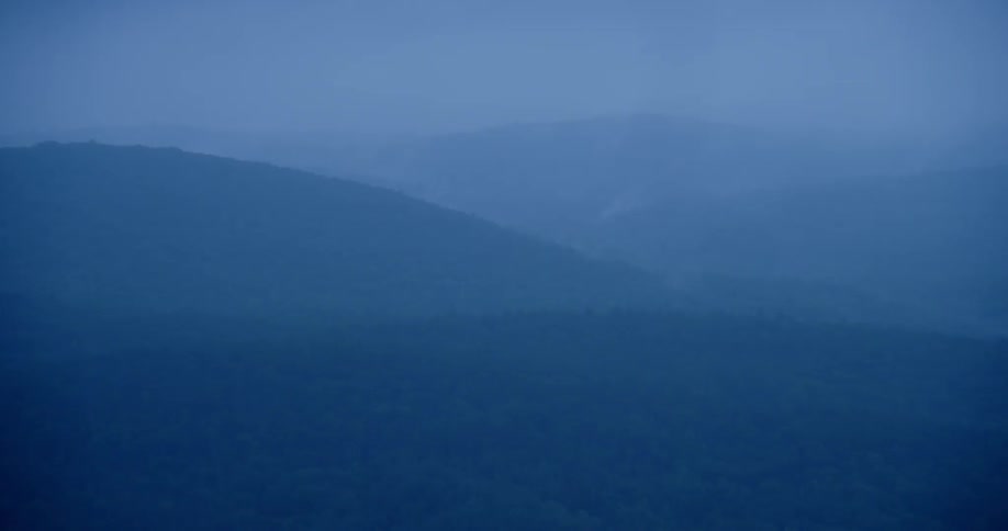 The tall hills are covered with fog