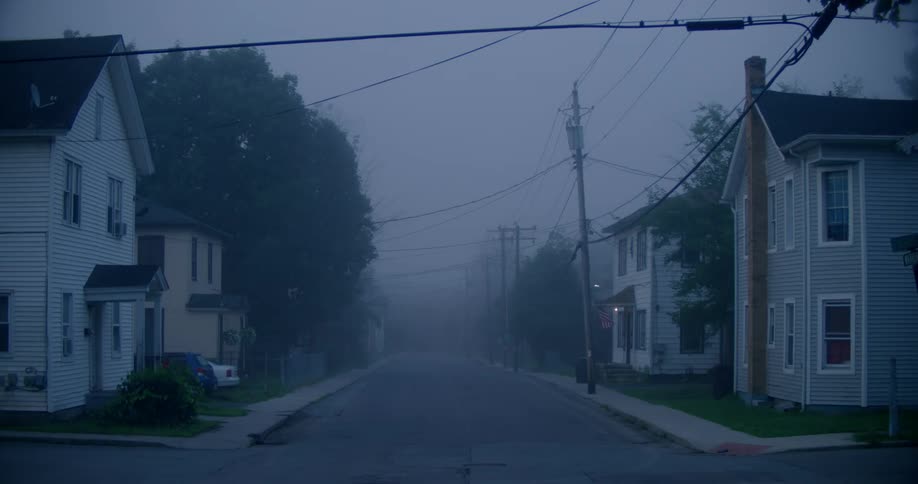 Looking down a road lined with houses at the fog in the distance