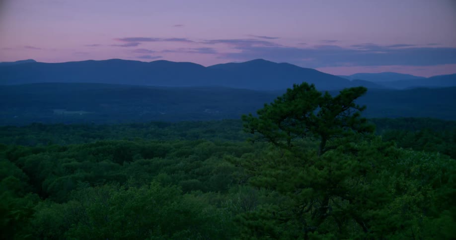 A field leading to a mountain at dusk