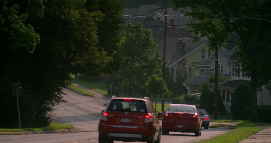 Cars driving down a rural city area