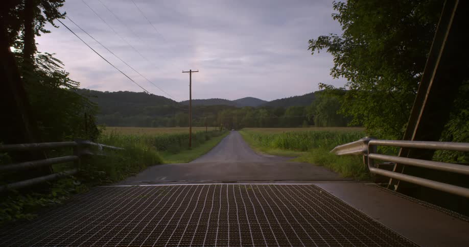 A rural road is shown on an overcast day