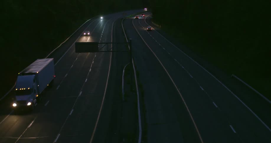 Traffic moving through a large highway area at sunset