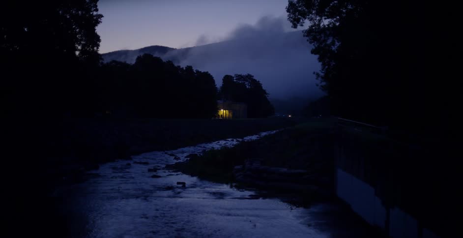 A river winds through a forest at dusk