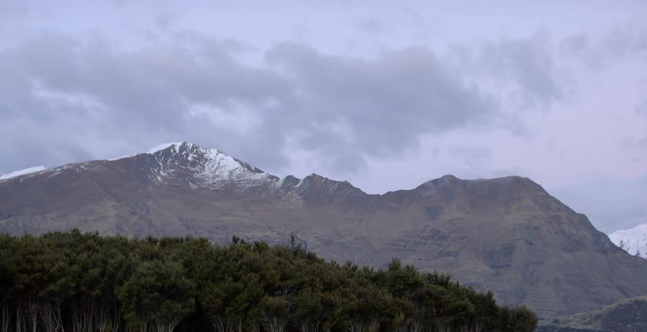 Snow capped mountains near a forest