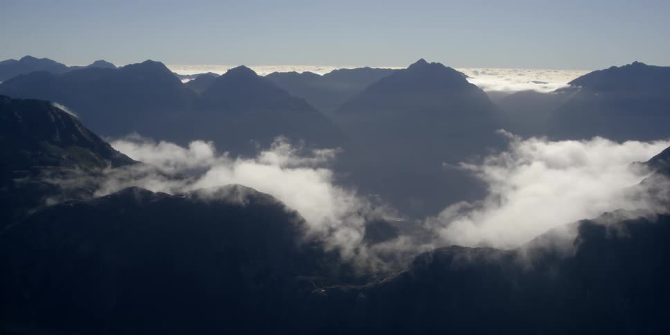 Clouds hovering over mountains on a sunny day