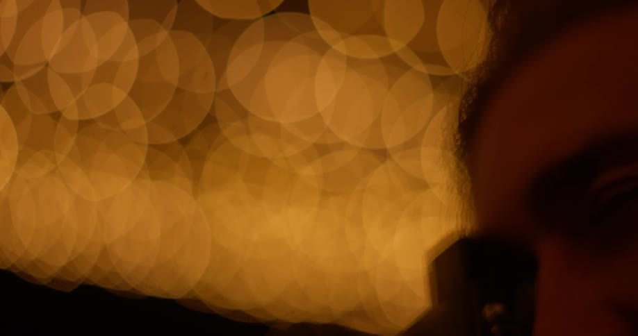 Close up of man taking pictures outside at night