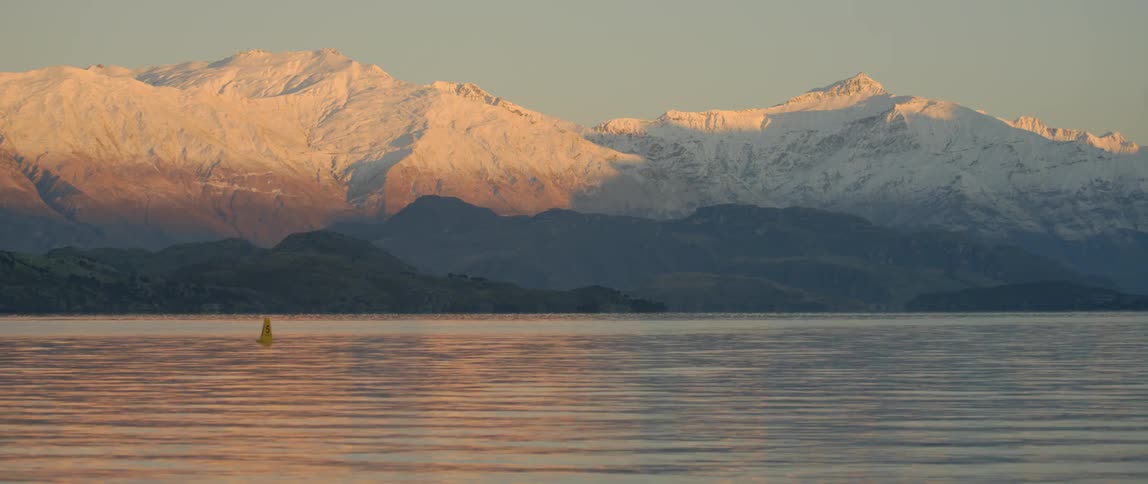 Lake flowing with mountains in the background