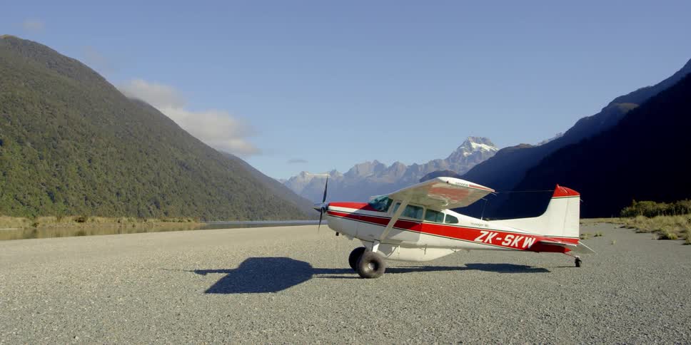 A red and white plane is parked on the runway