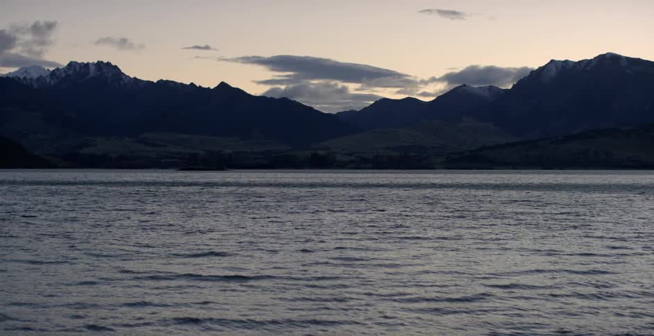 A lake near some mountains at dusk