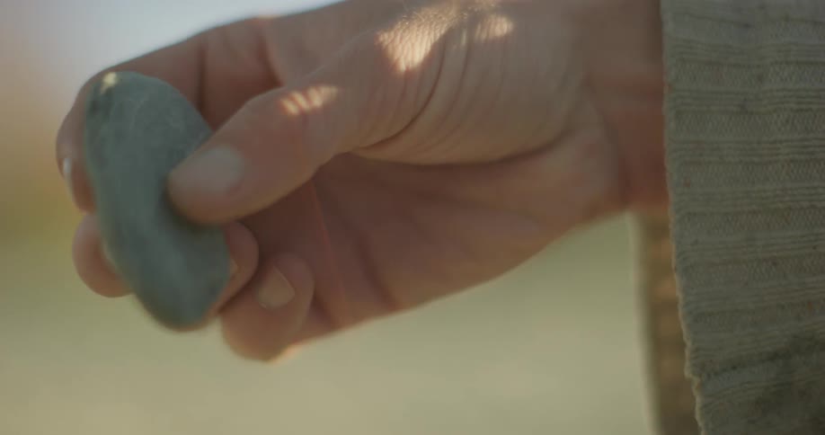 A person twirls a rock in their fingers
